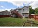 A spacious backyard with a deck, stairs, lawn, garden beds, and a privacy fence at 116 Remington Place Blvd, Dallas, GA 30157