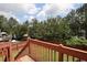 Enjoy the view from the deck overlooking a spacious, fenced backyard with lush greenery and mature trees at 116 Remington Place Blvd, Dallas, GA 30157
