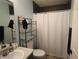 This cozy bathroom features tile flooring, a shower with a white curtain, and functional storage shelves at 116 Remington Place Blvd, Dallas, GA 30157