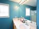 Bathroom with blue walls, large mirrors, and dual sinks with an abundance of natural light at 116 Remington Place Blvd, Dallas, GA 30157