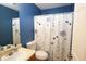 Bathroom with blue walls, a sink with a cream counter, and decorative shower curtain at 116 Remington Place Blvd, Dallas, GA 30157