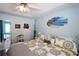 Bright bedroom with blue walls, beach art, ceiling fan, and connecting ensuite bathroom at 116 Remington Place Blvd, Dallas, GA 30157