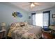 Bright bedroom with blue walls, beach art, ceiling fan, and white trimmed window showcasing natural light at 116 Remington Place Blvd, Dallas, GA 30157