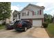 Two-story home features neutral siding, red shutters, brick accents, and a spacious driveway leading to a two-car garage at 116 Remington Place Blvd, Dallas, GA 30157