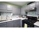 Modern kitchen with gray cabinets, white counter tops, stainless steel appliances, and stylish backsplash at 116 Remington Place Blvd, Dallas, GA 30157