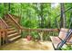 An outdoor deck has a swing and stairs to admire the serene surroundings of nature at 2261 Ravenwood Trl, Marietta, GA 30066