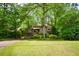 View of home's exterior surrounded by lush greenery and mature trees at 2261 Ravenwood Trl, Marietta, GA 30066