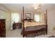 Spacious main bedroom featuring a four-poster bed, desk, and neutral decor at 2261 Ravenwood Trl, Marietta, GA 30066