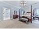 This primary suite has a four poster bed, neutral color palette, sitting bench and ensuite bath at 275 Frances Rd, Canton, GA 30114