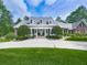 Inviting brick home boasts a manicured lawn, columned porch, and symmetrical landscaping creating stunning curb appeal at 275 Frances Rd, Canton, GA 30114