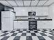Well-lit kitchen features crisp white cabinetry, black appliances, and checkerboard floors adding character at 275 Frances Rd, Canton, GA 30114
