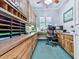 A home office with built in shelving and cabinets, a ceiling fan and a window at 275 Frances Rd, Canton, GA 30114