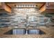 Close up of a stainless steel kitchen sink and granite countertops with tile backsplash at 5859 Bellingrath Way, Lithonia, GA 30058