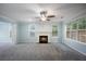 Cozy living room featuring a ceiling fan, fireplace, and large windows with views at 5859 Bellingrath Way, Lithonia, GA 30058