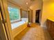 Primary bathroom featuring a jacuzzi tub, shower, and large window at 842 Treeline Dr, Conyers, GA 30016