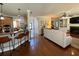 Modern living room with hardwood floors, a fireplace, and open access to kitchen and staircase at 842 Treeline Dr, Conyers, GA 30016