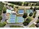 Aerial view of tennis courts and a pool in a community setting, surrounded by trees and parking at 960 River Valley Dr, Dacula, GA 30019