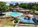 Community pool and playground with chairs, tables, and shade surrounded by trees and tennis courts at 960 River Valley Dr, Dacula, GA 30019