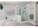 Modern bathroom featuring a glass-enclosed shower, soaking tub, and stylish tilework at 960 River Valley Dr, Dacula, GA 30019