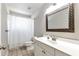 Bathroom with a ornate framed mirror, a white sink and cabinet and a bathtub with shower at 960 River Valley Dr, Dacula, GA 30019