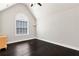 Bright bedroom with vaulted ceiling, dark hardwood floor, and a large window, creating a comfortable and inviting space at 960 River Valley Dr, Dacula, GA 30019