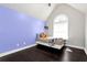 Bedroom features hard wood floors, purple accent wall, and an arched window for natural light at 960 River Valley Dr, Dacula, GA 30019