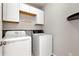 Laundry room features washer and dryer with upper cabinets and motivational wall art at 960 River Valley Dr, Dacula, GA 30019