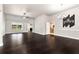 Open-concept living room with dark wood floors, decorative 'gather' wall art, and seamless flow to the kitchen at 960 River Valley Dr, Dacula, GA 30019