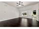 Bright living room with dark wood floors, a ceiling fan, large windows, and a doorway to another room at 960 River Valley Dr, Dacula, GA 30019