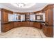 A spacious bathroom offers double vanity, granite countertops, dark wood cabinets, and decorative tile floor at 120 Kettering Trce, Tyrone, GA 30290