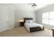 Carpeted bedroom with a bed, an end table, and a light fixture at 120 Kettering Trce, Tyrone, GA 30290
