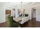 Bright dining room featuring crown molding, a modern chandelier, and wood flooring at 120 Kettering Trce, Tyrone, GA 30290