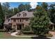 Charming brick home with dormer windows, complemented by mature trees and lush landscaping at 120 Kettering Trce, Tyrone, GA 30290