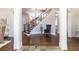 Grand foyer with hardwood floors, elegant staircase, decorative columns and natural light at 120 Kettering Trce, Tyrone, GA 30290