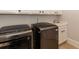 Bright laundry room with stainless steel washer and dryer units and a sink at 120 Kettering Trce, Tyrone, GA 30290