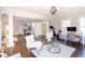 Bright living room with hardwood floors, columns, chandelier, exercise bike, and sitting area with white chairs at 120 Kettering Trce, Tyrone, GA 30290