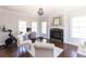 Cozy living room with a fireplace, workstation, and decorative chandelier at 120 Kettering Trce, Tyrone, GA 30290