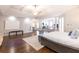 Expansive main bedroom with entertainment area, hardwood floors, tray ceiling, and king bed at 120 Kettering Trce, Tyrone, GA 30290