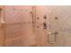Close-up of tiled shower with bench, rainfall shower head, handheld sprayer, and glass door at 120 Kettering Trce, Tyrone, GA 30290