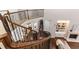 Open staircase with wood railing, hardwood floors, and a view to the living room with fireplace at 120 Kettering Trce, Tyrone, GA 30290