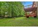 Lush green backyard with mature trees and a two-story deck attached to the home at 497 Fire Fly Dr, Tucker, GA 30084