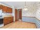 Bright kitchen featuring colorful wallpaper, wooden cabinets, and durable laminate flooring at 497 Fire Fly Dr, Tucker, GA 30084