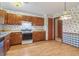 Cozy kitchen with wood cabinets, stainless steel appliances, and laminate floors at 497 Fire Fly Dr, Tucker, GA 30084