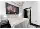 Minimalist bedroom with a large skyline art piece above the bed and an open bathroom with door at 878 Peachtree St # 601, Atlanta, GA 30309