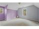 A room featuring 2 large windows, gray walls, and purple accent wall at 1645 Four Notch Rd, Carrollton, GA 30116