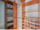 Walk-in closet with custom shelving for shoes and clothes with wooden floor and light at 1645 Four Notch Rd, Carrollton, GA 30116