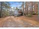 Exterior view showing a driveway leading to a house with an attached deck and a landscaped yard at 1645 Four Notch Rd, Carrollton, GA 30116