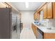 Well-lit kitchen features stainless steel appliances, wooden cabinets, and tile flooring at 1645 Four Notch Rd, Carrollton, GA 30116