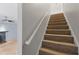 Carpeted staircase with wooden handrail leading to the second floor at 1645 Four Notch Rd, Carrollton, GA 30116