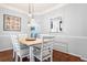 Dining room features a wood table, white chairs, hardwood floors and a pass through to the kitchen at 2865 Winter Rose Ct, Dunwoody, GA 30360